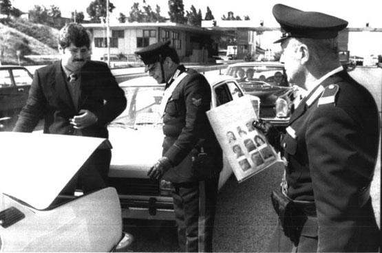 Un posto di blocco. Il carabiniere sulla destra ha in mano le fotografie dei possibili rapitori di Aldo Moro per le identificazioni (Ap)